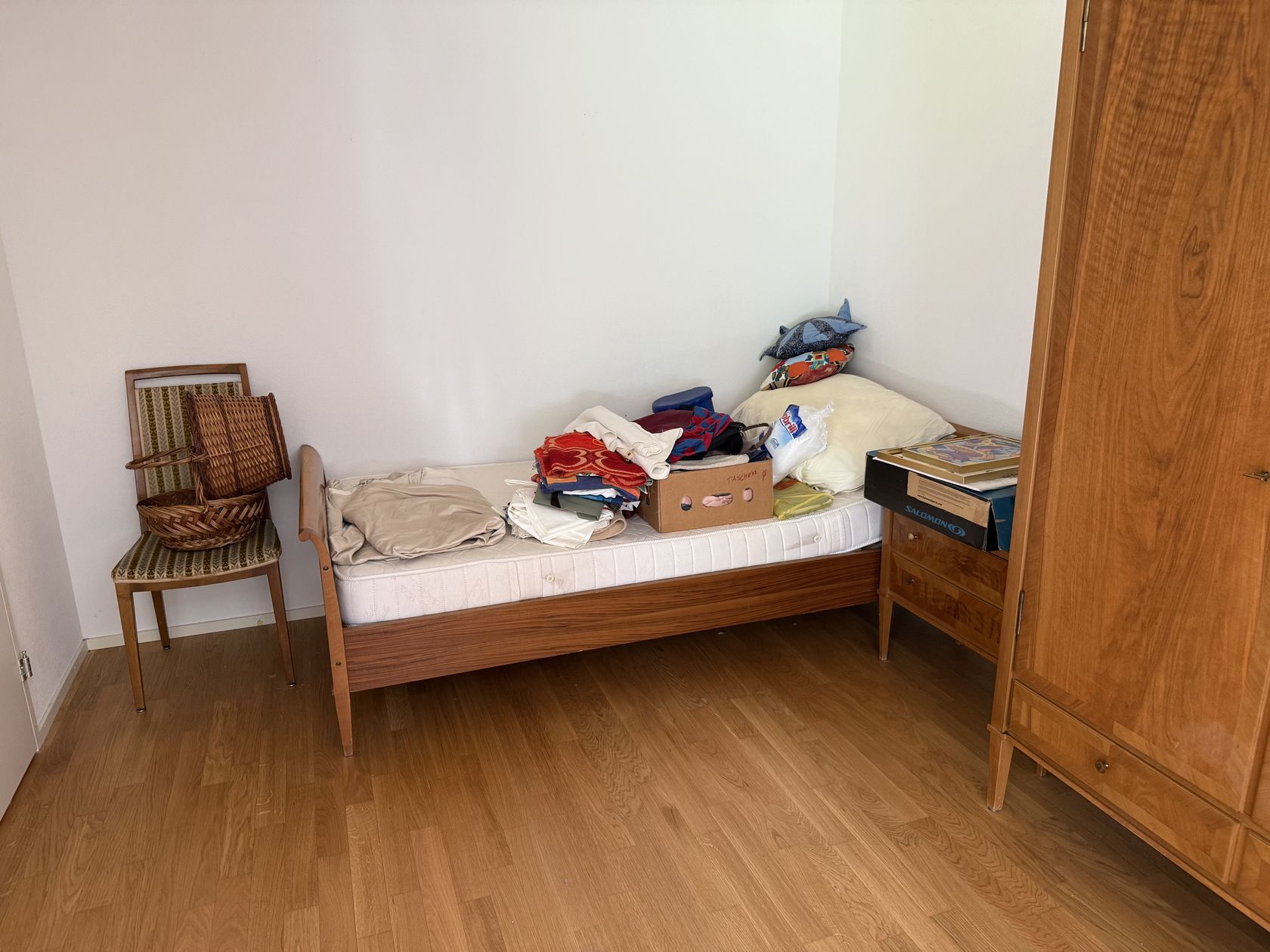 Zimmer vor einer Wohnungsräumung in Herrliberg, mit Bett, Schrank und Umzugskartons